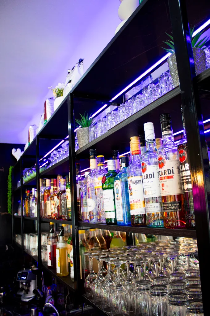 Backlit bar shelves with spirits and glassware at Amroo Shisha