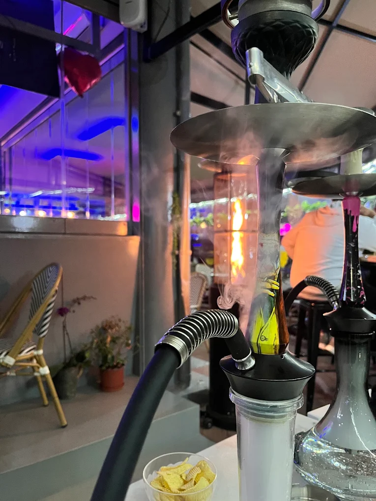 Lit hookah with glowing coals on a marble table at Amroo Shisha